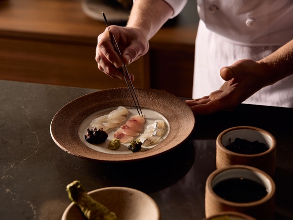 a chef preparing a dish at Atria, CBD