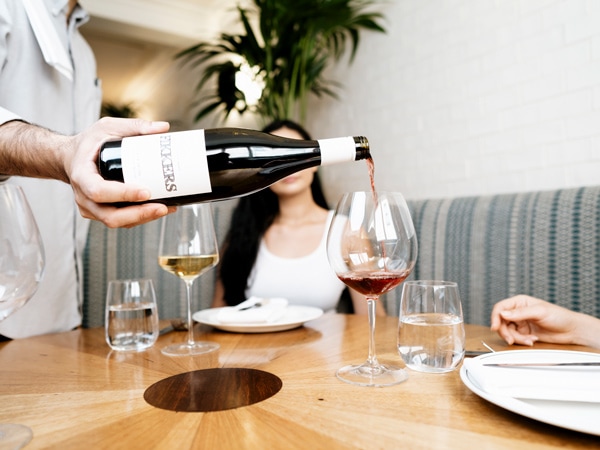 pouring wine into the glass at The Carlton Wine Room, Carlton