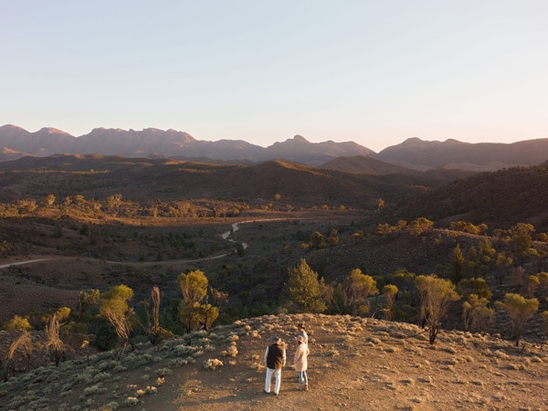 Couple on tour with a guide and Ikara-Flinders Ranges in the background