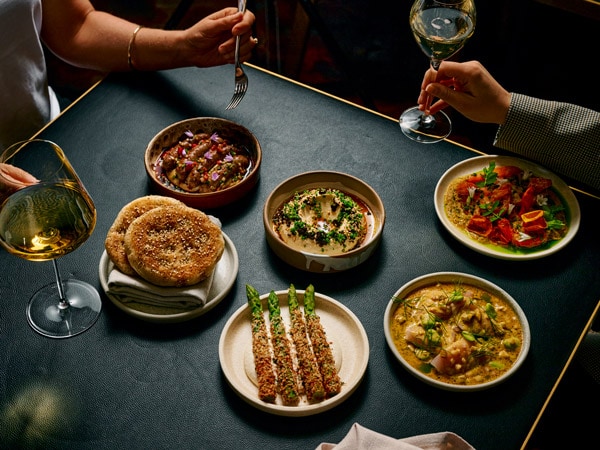 a dining table filled with an array of dishes at Maha, CBD