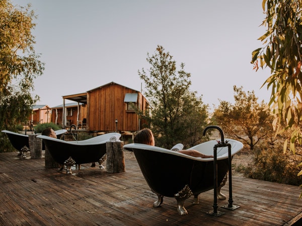 guests soaking in outdoor tubs at Saltbush Retreat in Longreach, Qld