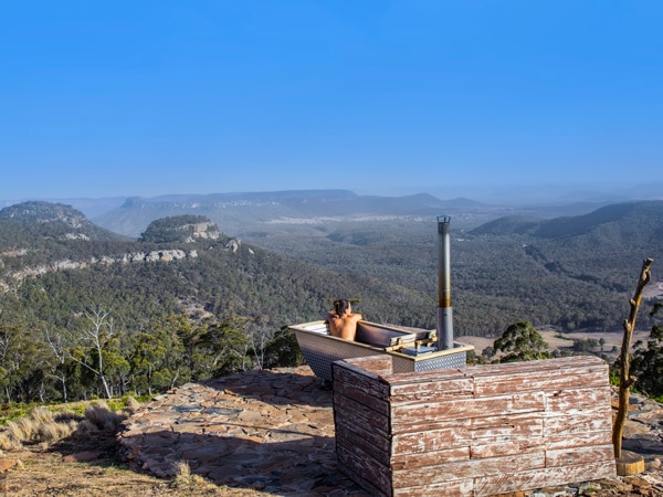 a woman relaxing in a bathtub overlooking Capertee Valley at Bubbletent Australia