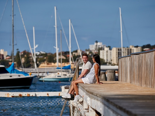 a couple sitting by the wharf at Forty Baskets Beach