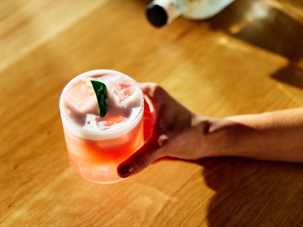 a hand holding a cocktail glass at Four Pillars Gin, Healesville