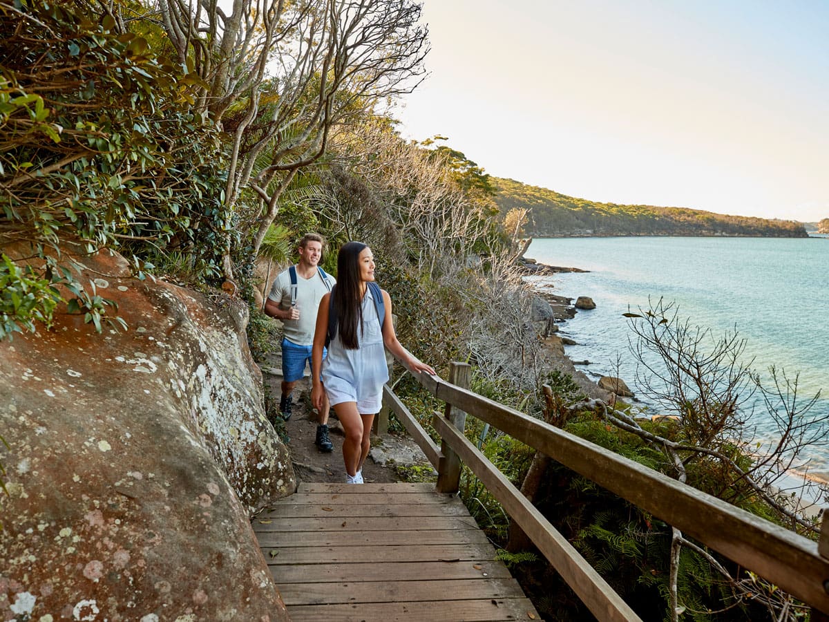 a couple enjoying the walk from Spit Bridge to Manly with scenic views across Sydney Harbour