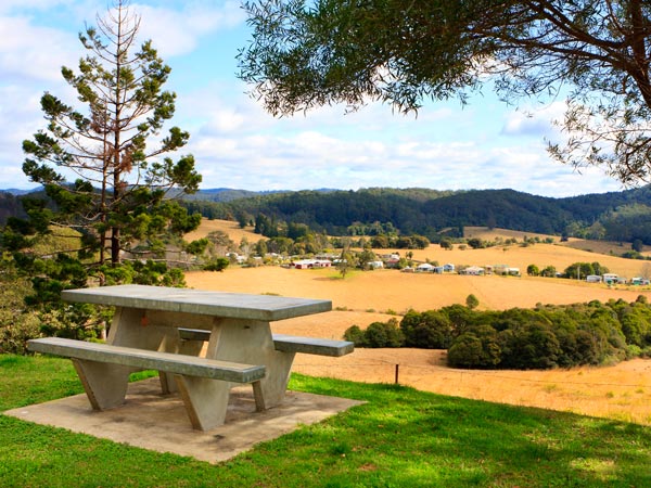 A picnic table overlooks a valley with the little village of Coramba