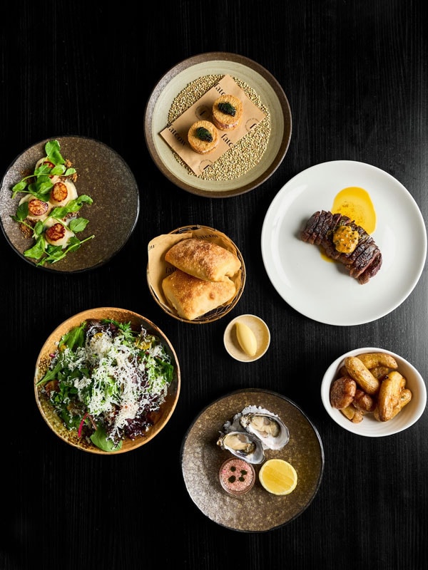 a spread of food on black background at Fatcow, Brisbane