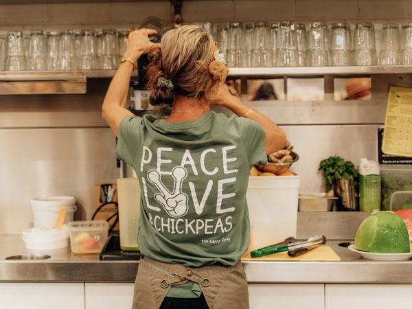 a staff at The Happy Frog cafe wearing a ‘Peace, Love and Chickpeas’ tee
