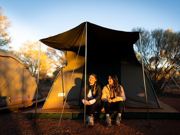a couple sitting outside their tent, Intrepid Travel