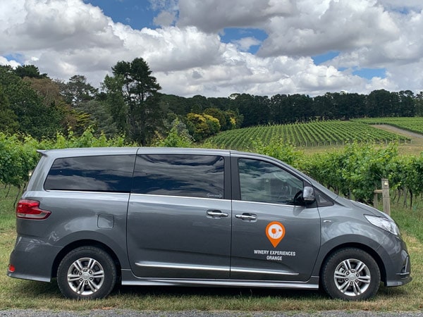 Winery Experiences Orange's tour bus parked at a winery