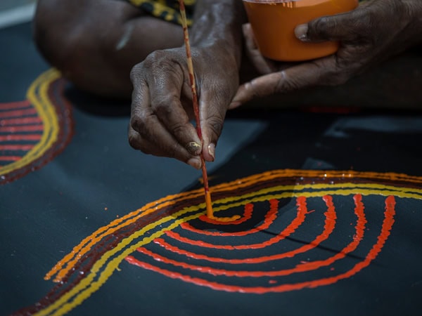 a close-up of a local artist creating an Aboriginal art at Yubu Napa Art Gallery