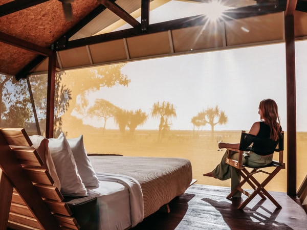 a woman sitting in a luxe safari tent, Bamurru Plains