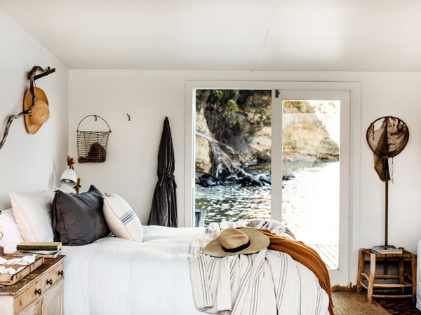 the bedroom with a sliding glass door overlooking the sea on Satellite Island, Tas