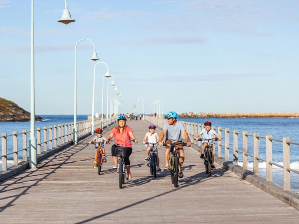 Family cycling the jetty in Coffs Harbour
