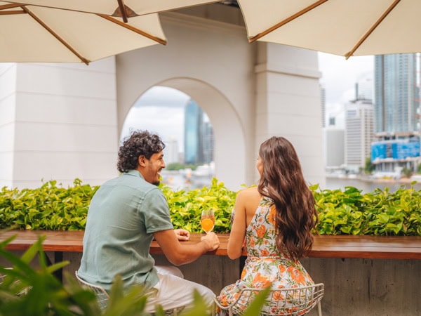 a couple enjoying drinks at Fiume Rooftop Bar, Brisbane