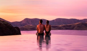 a couple sitting by the edge of the infinity pool during sunset at Lake Argyle Resort, WA
