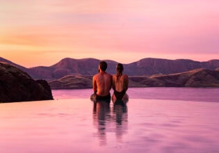 a couple sitting by the edge of the infinity pool during sunset at Lake Argyle Resort, WA