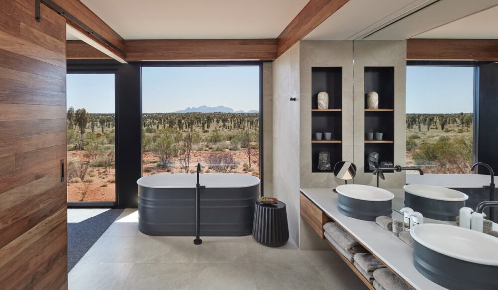 the bathroom at Longitude 131° with floor-to-ceiling windows overlooking Uluru landscape