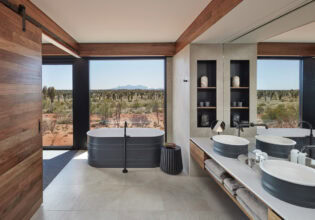 the bathroom at Longitude 131° with floor-to-ceiling windows overlooking Uluru landscape