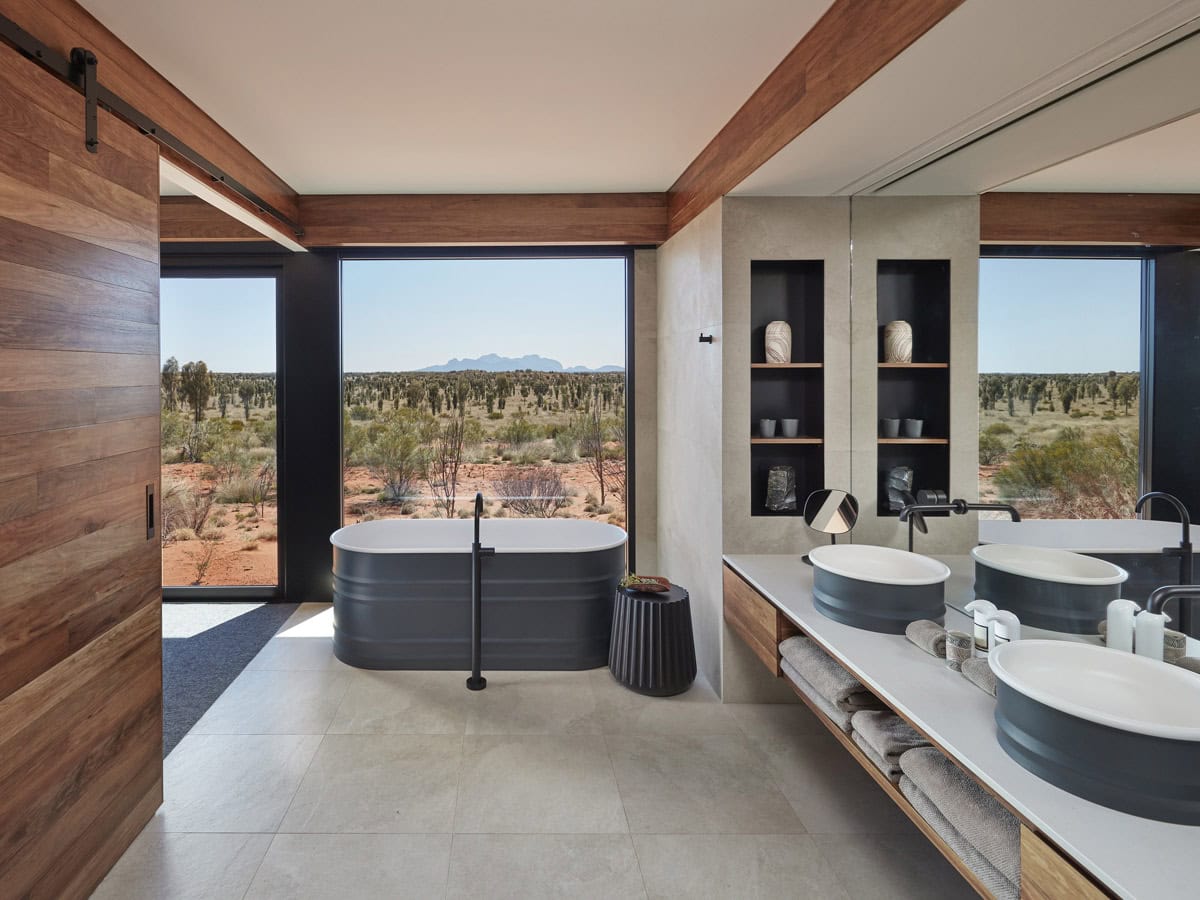 the bathroom at Longitude 131° with floor-to-ceiling windows overlooking Uluru landscape