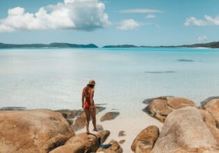 a person standing on a beach rock at Hill Inlet