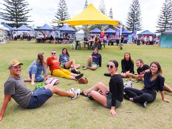 friends sitting on the picnic grounds of Harbourside Markets, Coffs Harbour