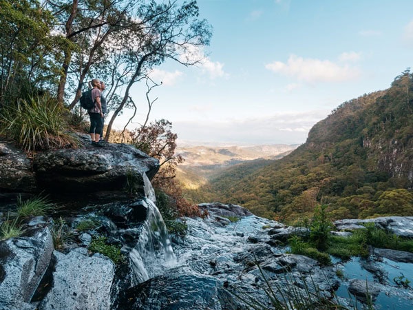 two hikers standing on top of a rock at Lamington National Park