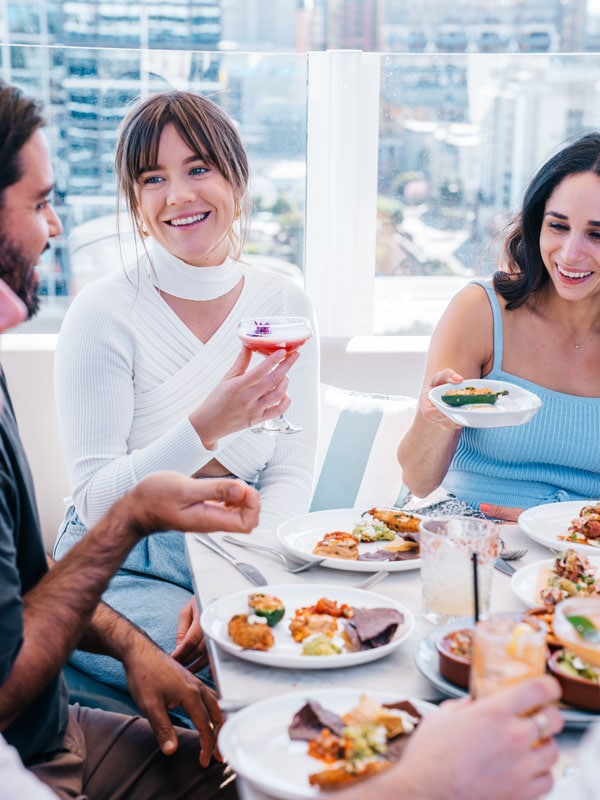 friends enjoying food and drinks at the rooftop bar of MAYA Mexican, Brisbane