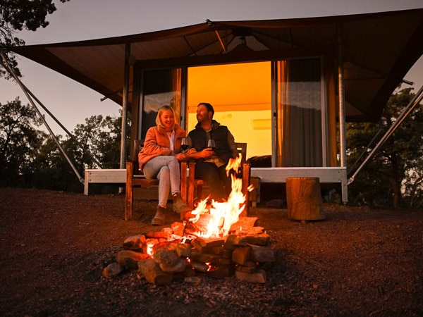 a couple sitting by the fire outside their tent at Wilpena Pound Resort