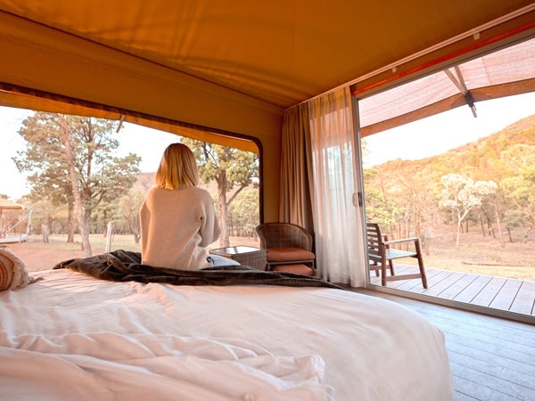 a woman relaxing inside her tent at Wilpena Pound Resort