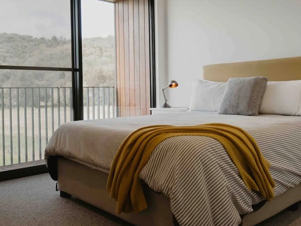 a bed set next to a balcony at The Black Shed, Mudgee