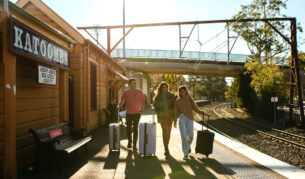 Young people with luggage catching a train at Katoombatrain station.