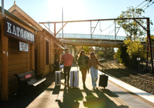 Young people with luggage catching a train at Katoombatrain station.