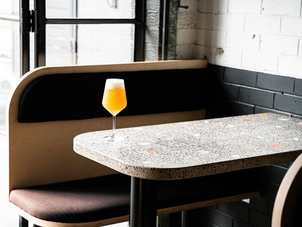 a glass of drink on the edge of the table at Range Brewing’s Range Taproom, Brisbane
