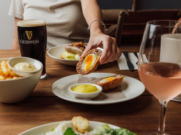 holding finger food with sauce on the table at The Rose & Crown, Brisbane pub