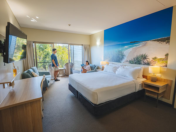 Couple relaxing in their King Resort Room, at Kingfisher Bay Resort