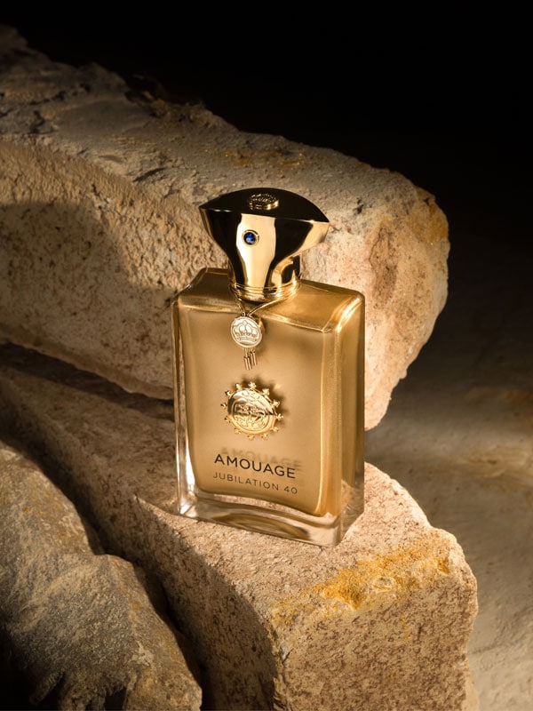 The bottle of the Amouage perfume sitting on some stone