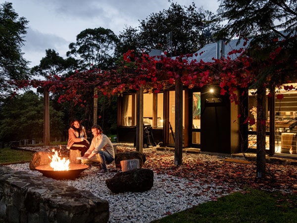 a couple sitting by the fire outside the Barranca homestead.