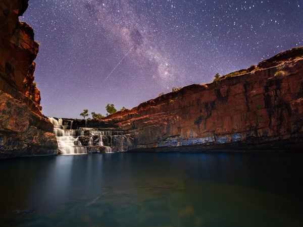 The night sky shines over Dalmanyi/Bell Gorge in WA