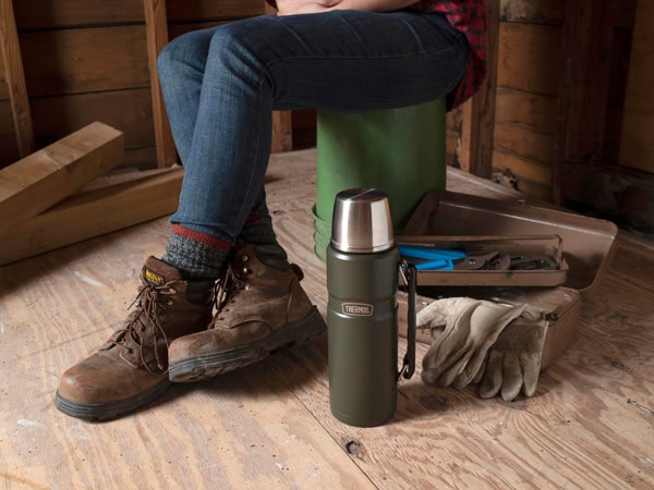 The Thermos Stainless King Flask resting on the floor of a working space.