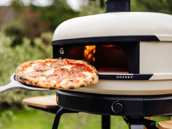 A Dome S1 pizza oven being used outside.