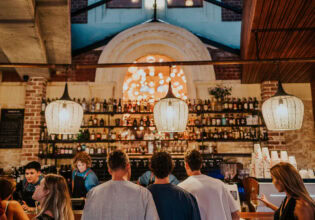 people lining up at the well-lit bar counter of Mr Chapple, Fremantle