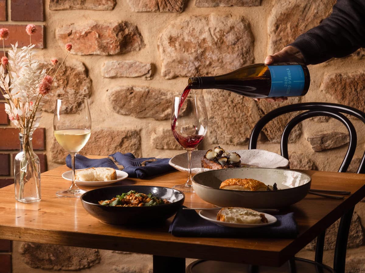 pouring wine into a glass on the dinner table at O’Leary Walker Restaurant