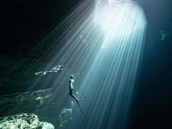 sunlight shines upon a diver underneath the Kilsby Sinkhole