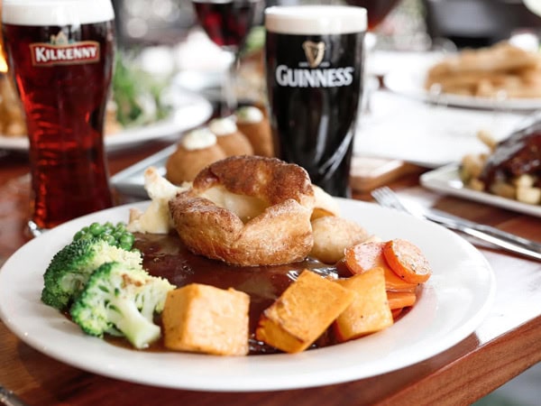 a close-up shot of food on a plate with beer on the table at Paddy Malone's, Perth