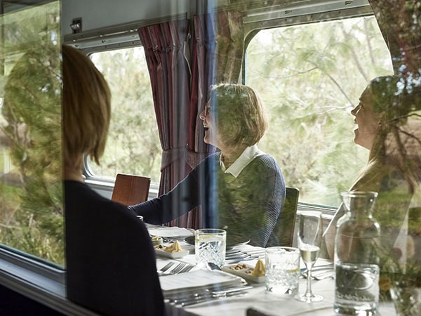 guests enjoying a meal aboard the qtrain