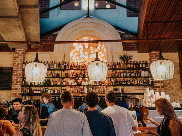 people lining up at the well-lit bar counter of Mr Chapple, Fremantle
