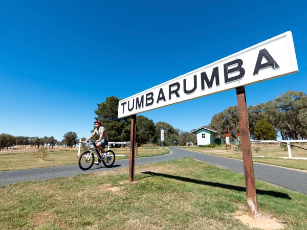 passing by a huge Tumbarumba sign on a bicycle