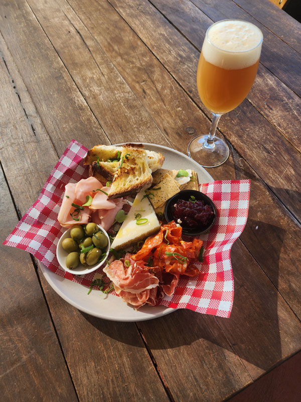 a food platter with a glass of beer at Txoko Brewing