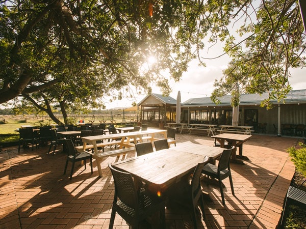 a garden-like setting with long wooden tables at Txoko Brewing